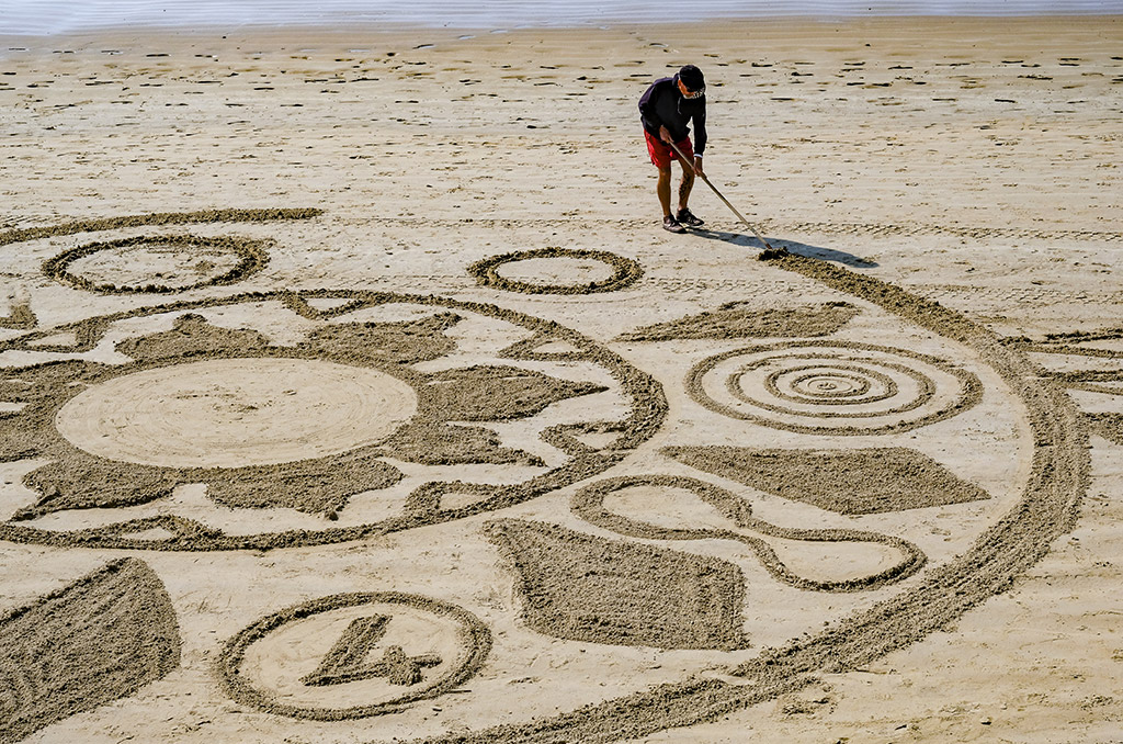 personnage dessinant sur le sable sur une plage des sables d'olonne ccas
