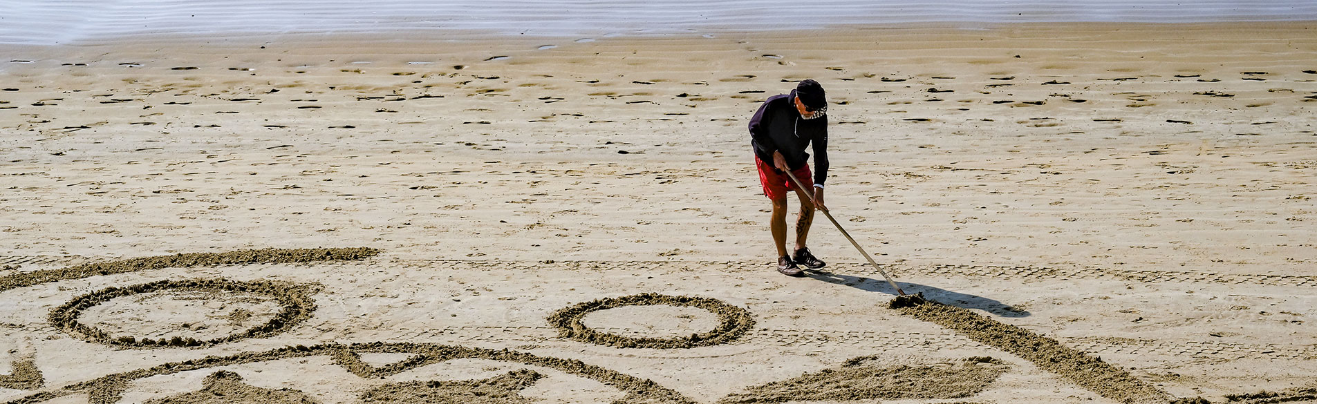 personne dessinant sur une plage des sables d'olonne