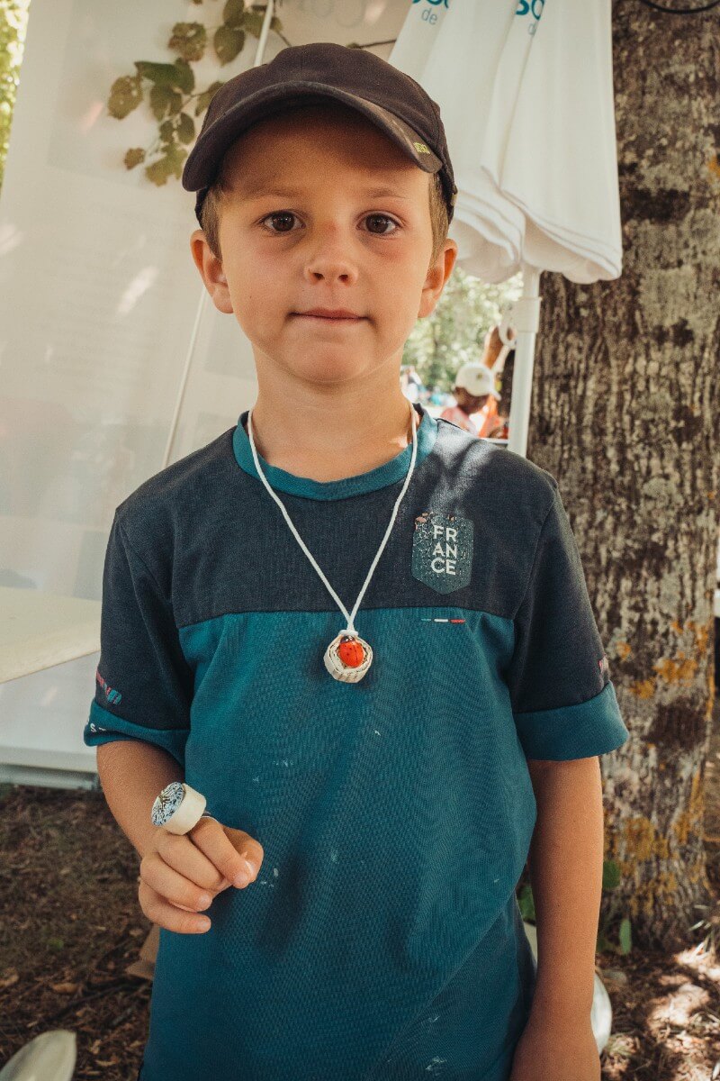 Atelier bijoux en papier avec Bérénice Benedetto, de la compagnie Axis mundi : livres de récup recyclés en pendentifs et bagues. Festival Partir en livre au village vacances CCAS de Savines-le-Lac (Hautes-Alpes), le 3 août 2023.
